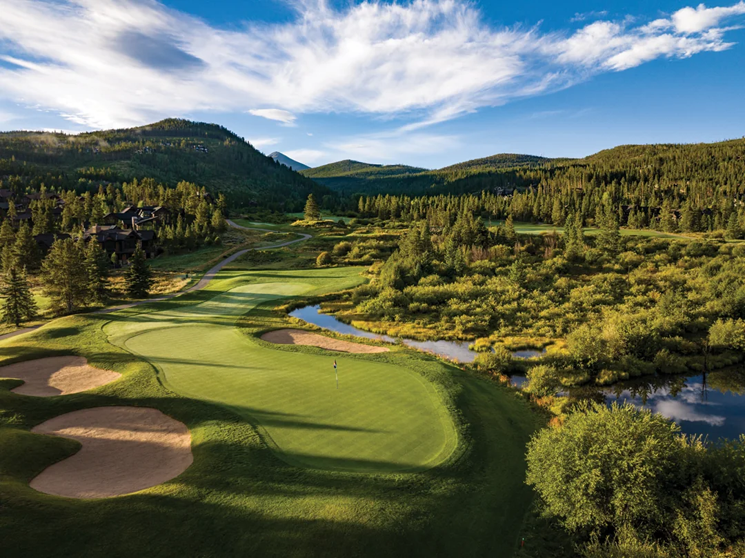 The 9th green of the Beaver Course at Breckenridge Golf Club, ringed by pines and peaks